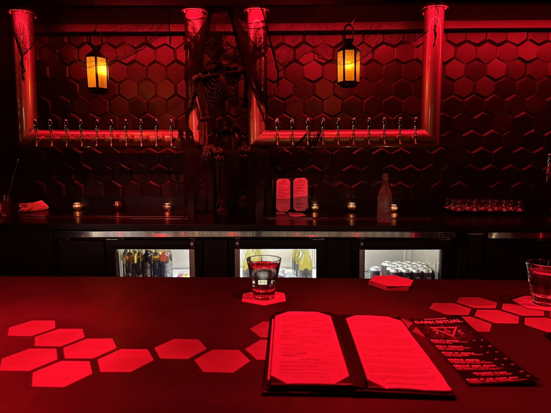 Inside Zymarium Meadery, decorated for Halloween with red lighting and spooky decor